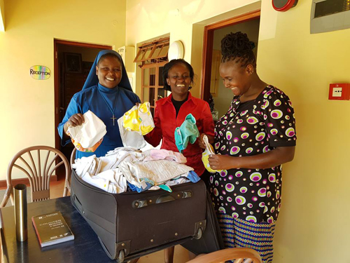 three women opening a case of cloth nappies