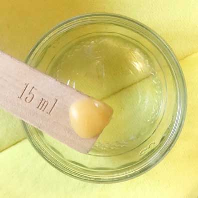 solid lanolin on a spoon ready to dissolve into hot water